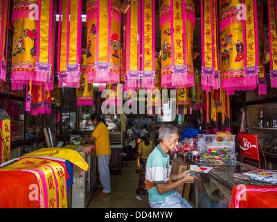 Bangkok, Thailand. 26. August 2013. Ein Shop-Arbeiter in BangkokÃƒÂ ¢?? s Chinatown macht Dekorationen für den hungrigen Geist-Monat. Die siebten Mondmonats (August - September 2013) ist, wenn die chinesische Gemeinschaft, dass HellÃƒÂ glaubt ¢?? s Tor wird geöffnet, um die Geister in der menschlichen Welt für einen Monat frei herumlaufen zu lassen. Viele Haushalte und Tempeln hält Gebetszeremonien während der einmonatigen Hungry Ghost Festival (Phor Thor) um die Geister zu besänftigen. Stockfoto