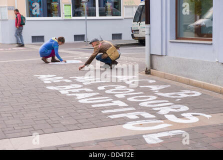 Aktivisten schreiben anti-rassistische Parolen auf der Straße gegen den Anti-Roma-Marsch der Rechtsextremisten in Ceske Budejovice, Tschechische Republik am 24. August 2013 zu protestieren. Rechtsradikale marschierten auf dieser Strecke in Budweis. (Foto/David Veis CTK) Stockfoto