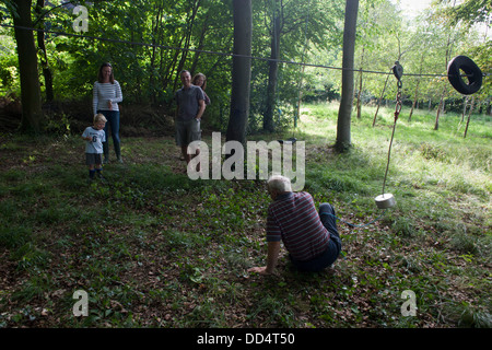 Eine 70 jährige aktive Großvater fällt auf den Boden nach ein Waldgebiet hausgemachte Seilrutsche fahren auf einem privaten Grundstück in Somerset. Stockfoto