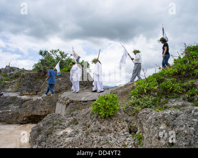 Dorfältesten machen ihren Weg zum Strand führt Gebete beim Unjami Festival auf Kouri Insel Okinawa Stockfoto