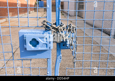 Große schwere Zahlenschloss Vorhängeschloss und Kette auf abgeschlossenem Grundstück blau Stockfoto