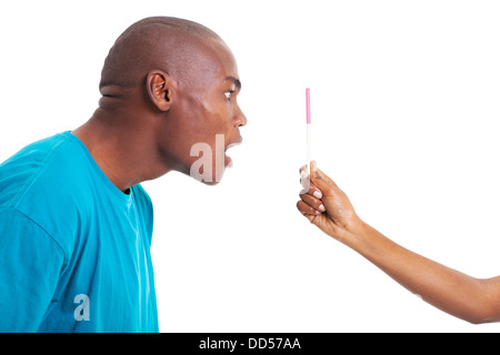 überrascht junge Afrikaner betrachten Freundin Schwangerschaftstest isoliert auf weiss Stockfoto