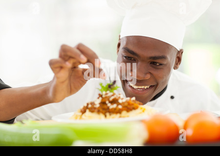 Porträt von Afro amerikanische Chefkoch im Restaurantküche Garnierung Nudelgericht Stockfoto