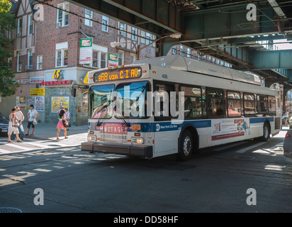 Ein Bus fährt unter den erhöhten Schienen der Brighton Linie der New Yorker u-Bahn Stockfoto