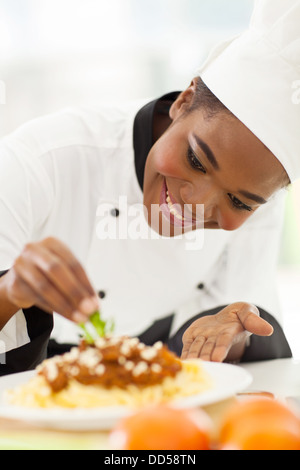 glücklich afroamerikanische Chef in der Küche Dekoration Nudelgericht Stockfoto
