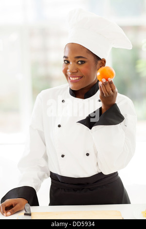 schöne weibliche afrikanische Jungkoch mit frischen Tomaten Stockfoto