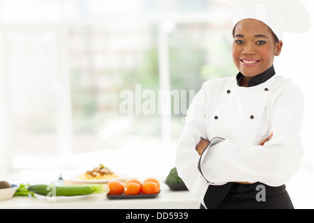 attraktive afrikanische amerikanische Köchin mit in Restaurantküche verschränkten Armen Stockfoto