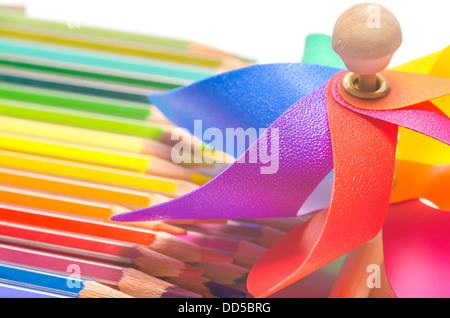 Bunten Spielzeug-Windrad mit einer Sammlung von Farbstifte in den Farben des Regenbogens, Erinnerungen an eine kreative Kindheit Stockfoto