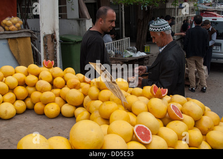 Ein unbekannter alten Mann mit traditionellen Kappe verkauft Grapefruits in einem offenen Markt am 19. April 2009 in Izmir, Türkei. Stockfoto