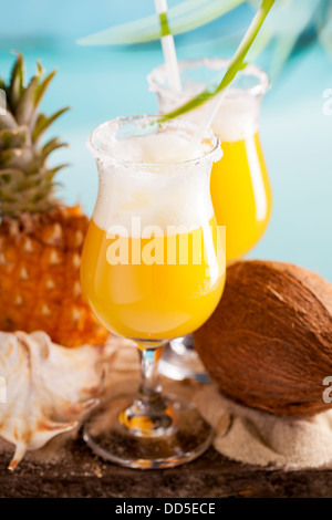 Cocktail aus Ananassaft, Rum, Likör auf Tisch am Himmelshintergrund Stockfoto