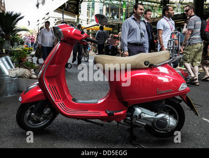 Ein rote Vespa-Roller in Borough Market in London geparkt. Stockfoto