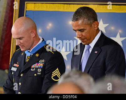 Washington, D.C., USA. 26. August 2013. US-Präsident Barack Obama neigt seinen Kopf im Gebet nach der Vergabe der Medal Of Honor für auffällige Galanterie, Staff Sergeant Ty M. Carter, US Army, während einer Zeremonie im East Room des weißen Hauses in Washington, D.C. USA, 26. August 2013. Staff Sergeant Carter wird für die mutigen Taten während seiner Tätigkeit als Kavallerie Scout mit Bravo Truppe, 3. Staffel, 61. Kavallerieregiment, 4th Brigade Combat Team, 4. US-Infanteriedivision, während der Kampfhandlungen im Kamdesh Bezirk, Nuristan Provinz, Afghanistan am 3. Oktober 2009 geehrt. Personal... Stockfoto