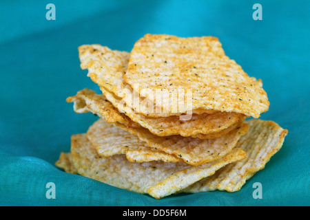 Gebackene Kartoffelchips mit mediterranen Kräutern auf grünem Hintergrund Stockfoto