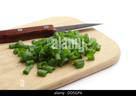 Gehackte Frühlingszwiebeln auf ein Schneidbrett aus Holz Stockfoto