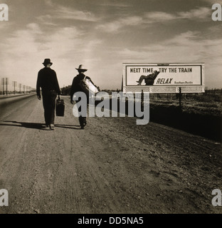 Zwei Männer gehen in Richtung Los Angeles März 1937. Vor ihnen ist eine südliche pazifische Eisenbahn Werbetafel lesen, "das nächste Mal versuchen Stockfoto