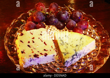 Wensleydale mit Preiselbeeren und Blue Stilton Käse mit roten Trauben auf einer Glasplatte stehen, England, Vereinigtes Königreich, West-Europa. Stockfoto