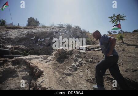 Silwan, Jerusalem, Palästina. 26. August 2013. Khaled al-Zeer al-Husaini, 39, geht vor seiner Höhle im Osten Jerusalems arabische Viertel Silwan, 26. August 2013. Al-Husaini ist Vater von fünf Kinder Leben in einer Höhle, das war ein Stall für die Tiere, nach israelische Behörden seinen eigenen vier Wänden unter dem Vorwand der Gebäude ohne Genehmigung Kredit vor 3 Tagen abgerissen: Saeed Qaq/APA Images/ZUMAPRESS.com/Alamy Live News Stockfoto