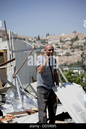 Silwan, Jerusalem, Palästina. 26. August 2013. Khaled al-Zeer al-Husaini, 39, spricht am Telefon, als er in den Trümmern seines Hauses im Stadtteil East Jerusalem arabischen von Silwan, 26. August 2013 sucht. Al-Husaini ist Vater von fünf Kinder Leben in einer Höhle, das war ein Stall für die Tiere, nach israelische Behörden seinen eigenen vier Wänden unter dem Vorwand der Gebäude ohne Genehmigung Kredit vor 3 Tagen abgerissen: Saeed Qaq/APA Images/ZUMAPRESS.com/Alamy Live News Stockfoto