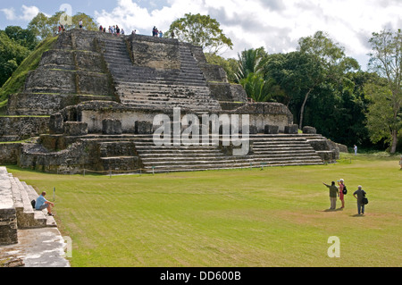 Belize, Mittelamerika, Altun Ha, Touristen in der Frontseite und auf die Tempel von Mauerwerk Altäre in Plaza B von den Maya-Ruinen. Stockfoto