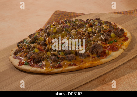 Eine Cheeseburger-Pizza ist servierfertig. Stockfoto