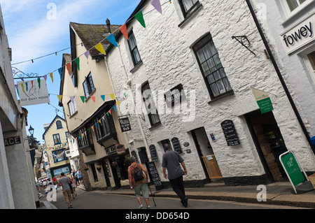 Horizontale Ansicht von Menschen zu Fuß auf einer schmalen Straße in Fowey an einem sonnigen Tag. Stockfoto