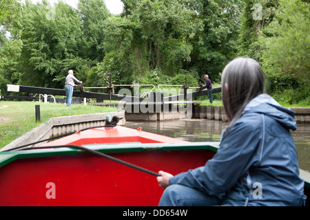 Eine Nahaufnahme Ofwoman halten ein Seil, eine schmale Boot (Barge) zu sichern, während eine Sperre in der Ferne geöffnet wird. Stockfoto