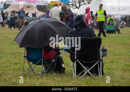 Horizontale Ansicht derjenigen, die auf einem Musikfestival im strömenden Regen. Stockfoto