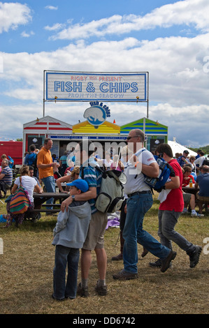 Vertikale Ansicht von Menschen durch einen Fish and Chips Stand auf einem Festival in der Sonne stehen. Stockfoto