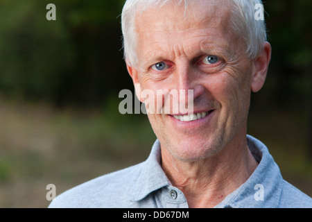 Closeup Portrait glückliches Gesicht der grauhaarige alte Mann. Im Freien. Im Park. Blaue Jeans. Graues T-shirt. Stockfoto