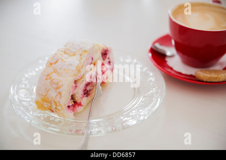 Attraktiven Dessert auf weißen Teller neben Kaffee Stockfoto