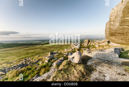 Woman sitting on Top of Kilmar Tor auf Bodmin Moor in Cornwall, Vintage-Effekt. Stockfoto