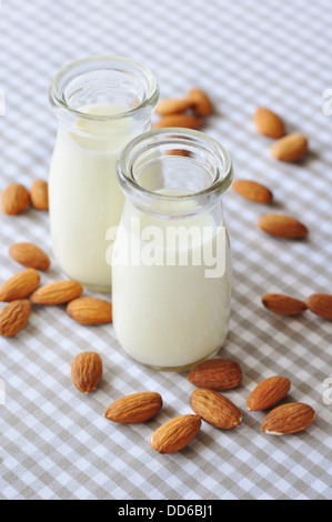 Mandel mit Mandel-Milch in Glasflaschen auf karierten Hintergrund Stockfoto