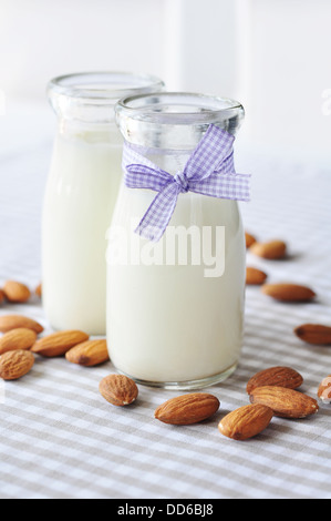 Mandel mit Mandel-Milch in Glasflaschen auf karierten Hintergrund Stockfoto