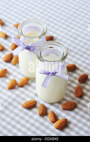 Mandel mit Mandel-Milch in Glasflaschen auf karierten Hintergrund Stockfoto