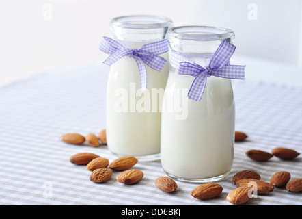 Mandel mit Mandel-Milch in Glasflaschen auf karierten Hintergrund Stockfoto