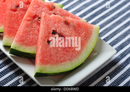 In Scheiben Wassermelone auf einem Teller auf blauem Hintergrund Stockfoto