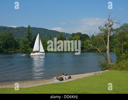 Junges Paar relaxen am Strand, Cockshott Point Lake Windermere, Bowness, Lake District National Park, Cumbria, England UK Stockfoto