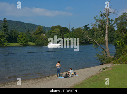 Junges Paar relaxen am Strand, Cockshott Point Lake Windermere, Bowness, Lake District National Park, Cumbria, England UK Stockfoto