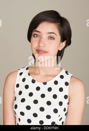 Porträt des jungen selbstbewussten Frau im gepunkteten Kleid Stockfoto