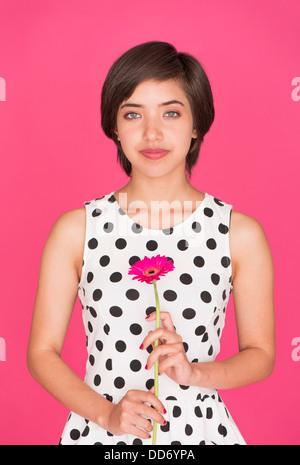 Romantische Porträt des jungen multirassische Frau hält ein rosa Gerbera Gänseblümchen Stockfoto