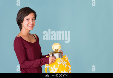 Porträt von lächelnden jungen multirassische Frau recycling Metall Dosen Stockfoto