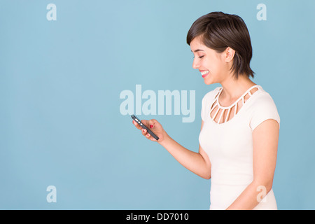 Glückliche und unbeschwerte junge Frau liest SMS auf Handy Stockfoto