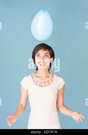 Schöne junge multirassische Frau Spaß mit blauen Ballon an der Feier Stockfoto