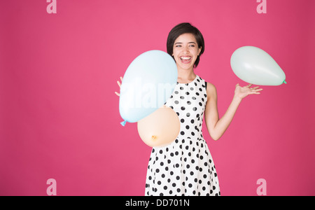 Schöne junge multirassische Frau Spaß mit Ballons an der Feier Stockfoto