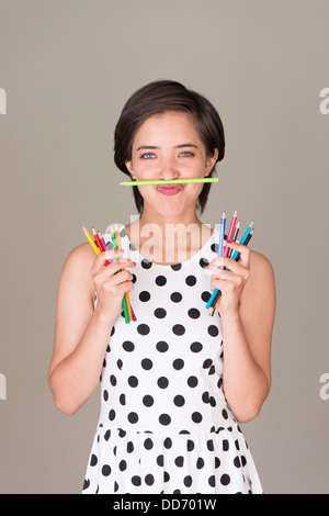 Schöne junge Frau multirassische Spaß und zeigt einen Satz Buntstifte Stockfoto