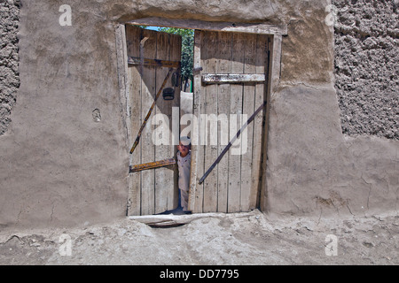 Ein kleines afghanischen Kind steht in einer Tür beobachten US Militärpatrouille 19. August 2013 im Bezirk Deh Yak, Provinz Ghazni, Afghanistan. Stockfoto