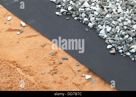 Geotextil Schicht zwischen grauen Kies- und Sandboden Stockfoto