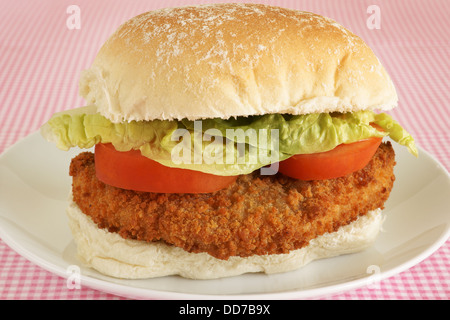 Hähnchenfilet Burger in Semmelbrösel mit Salat und Tomate auf ein frisches Brot Brötchen Stockfoto