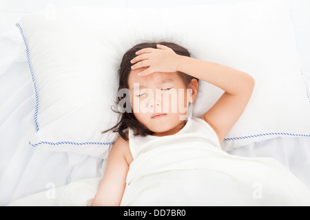 Kleines Mädchen mit Krankheit auf dem Bett Stockfoto