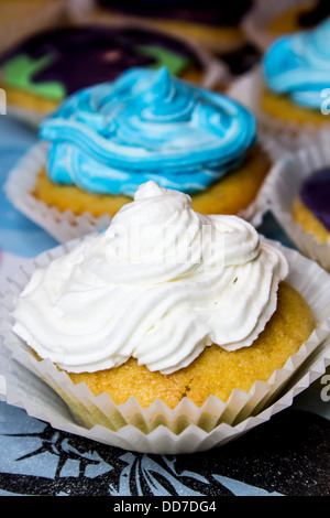 Einige farbige Muffins mit Sahne Stockfoto
